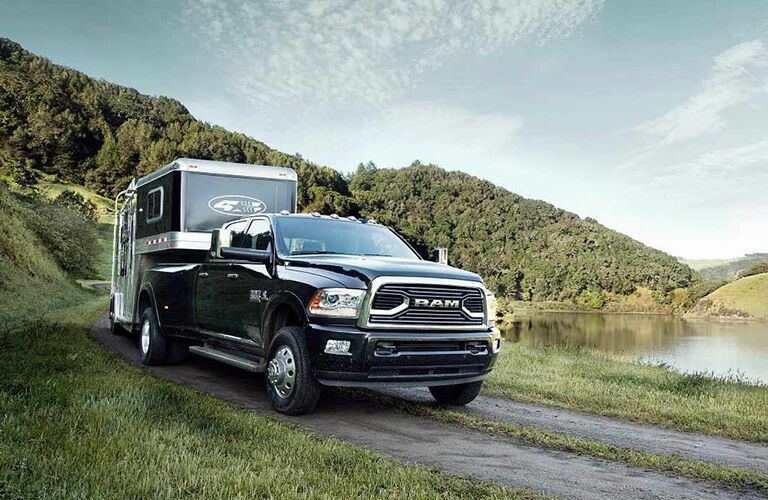 black 2018 Ram 3500 hauling a trailer next to a lake