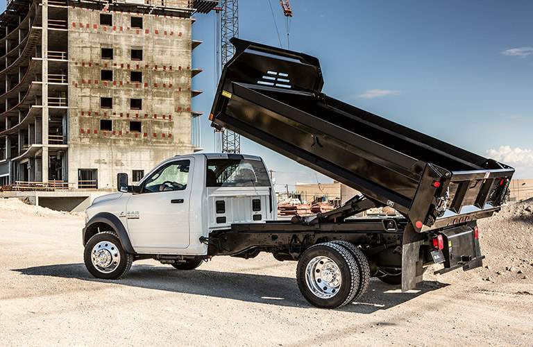 white 2018 Ram 5500 Chassis Cab serving as a dump truck on a work site