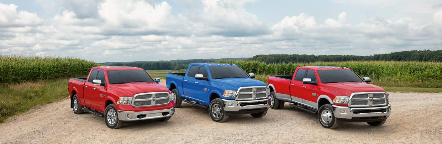 a selection of red and blue 2018 Ram Harvest Edition trucks with a cornfield in the background