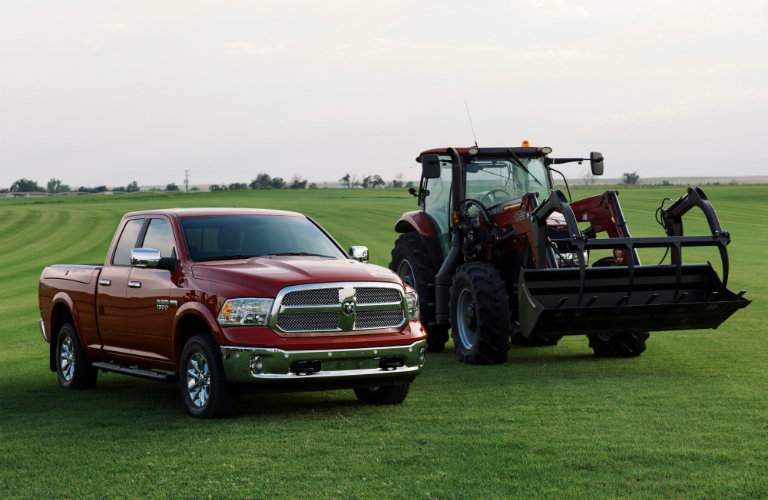2018 Ram Harvest Edition on a flat field parked next to a piece of farm equipment