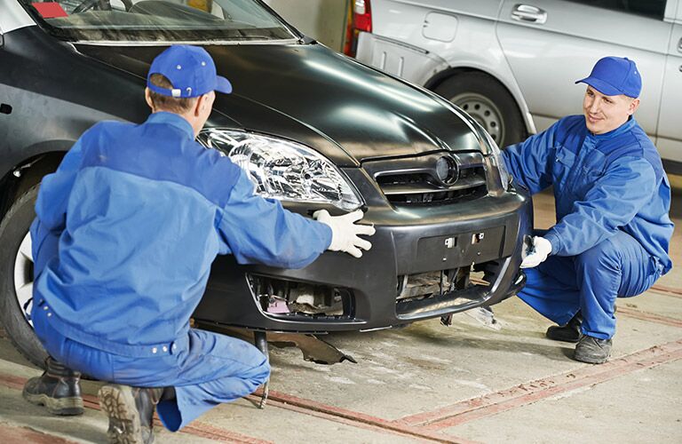 technicians checking out a car for repair