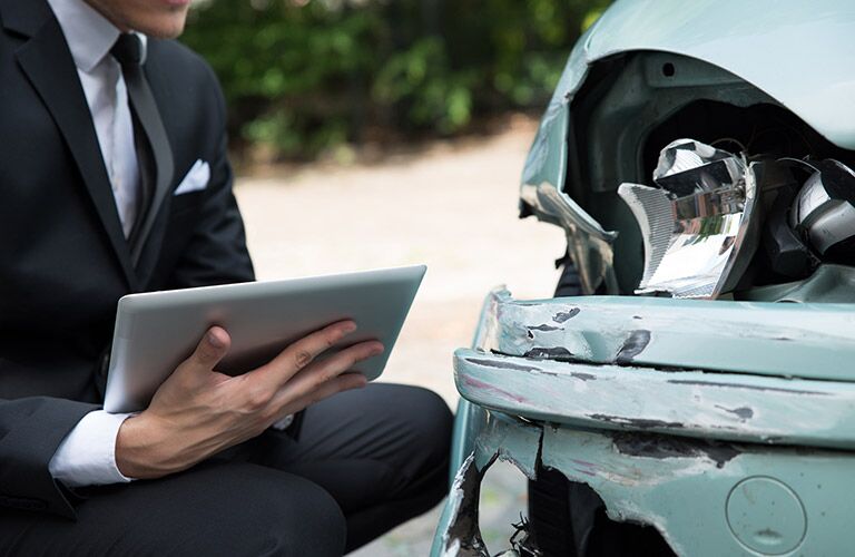 insurance person evaluating damage after a crash