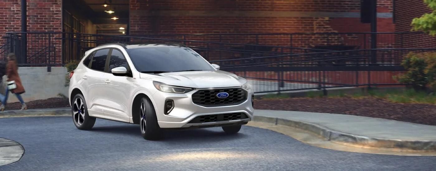 White 2023 Ford Escape parked outside of a brick building