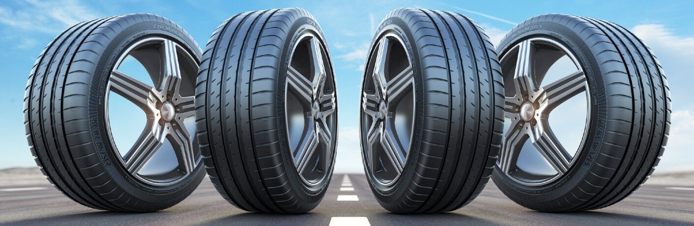 four tires standing upright in a row on a highway