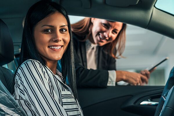 Young woman sitting in brand new car. Young woman sitting in brand new car.