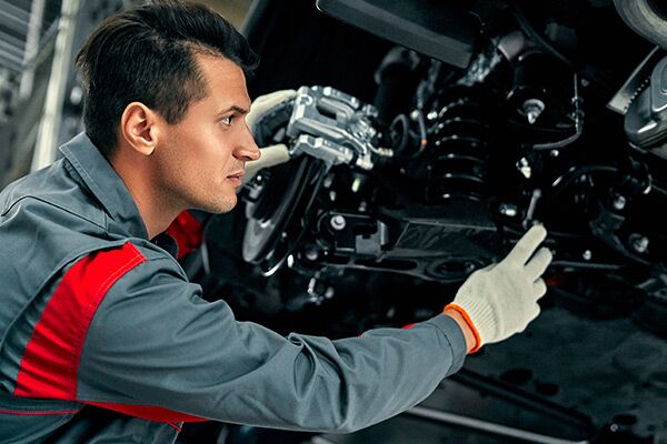 Mechanic in uniform is working in auto service. Car repair and maintenance. Mechanic in uniform is working in auto service. Car repair and maintenance.