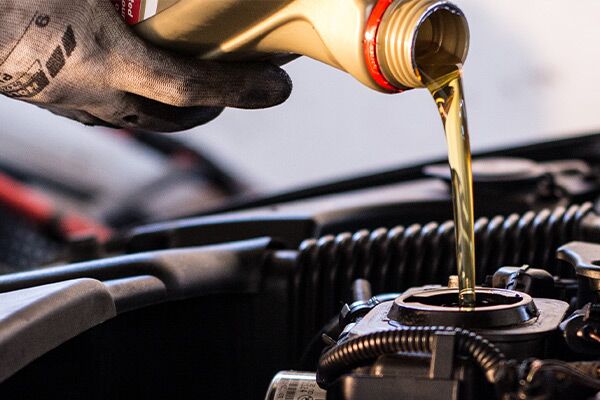 Mechanic fills the engine with engine oil Mechanic fills the engine with engine oil