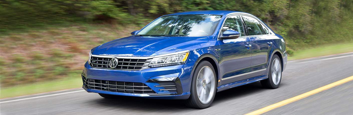 Blue 2018 Volkswagen Passat with blurred foliage background