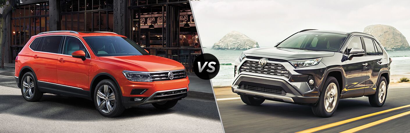 Front passenger angle of an orange 2019 Volkswagen Tiguan on left VS front driver angle of a black 2019 Toyota RAV4 on right