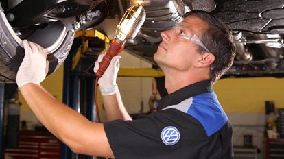 Volkswagen Care Plan Details Volkswagen mechanic looking under car