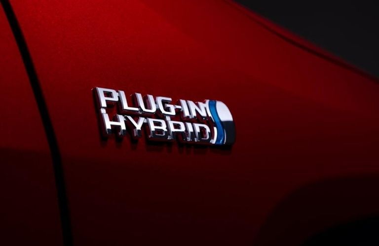 The plug-in hybrid logo on a red 2022 Toyota RAV4 Hybrid.