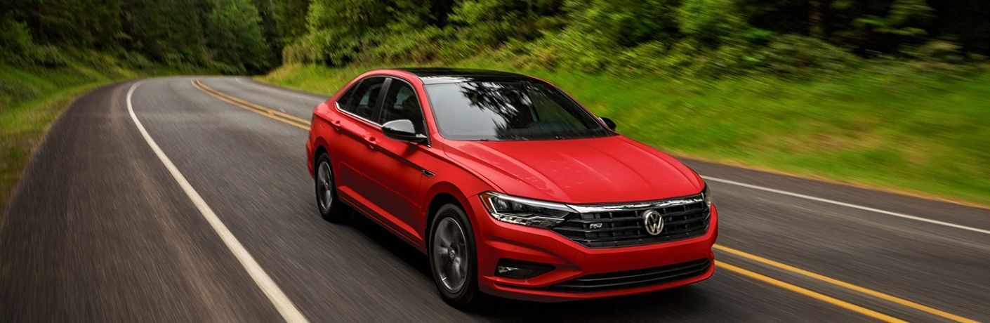 Used Volkswagen Jetta Red driving on the road Used Volkswagen Jetta Red driving on the road