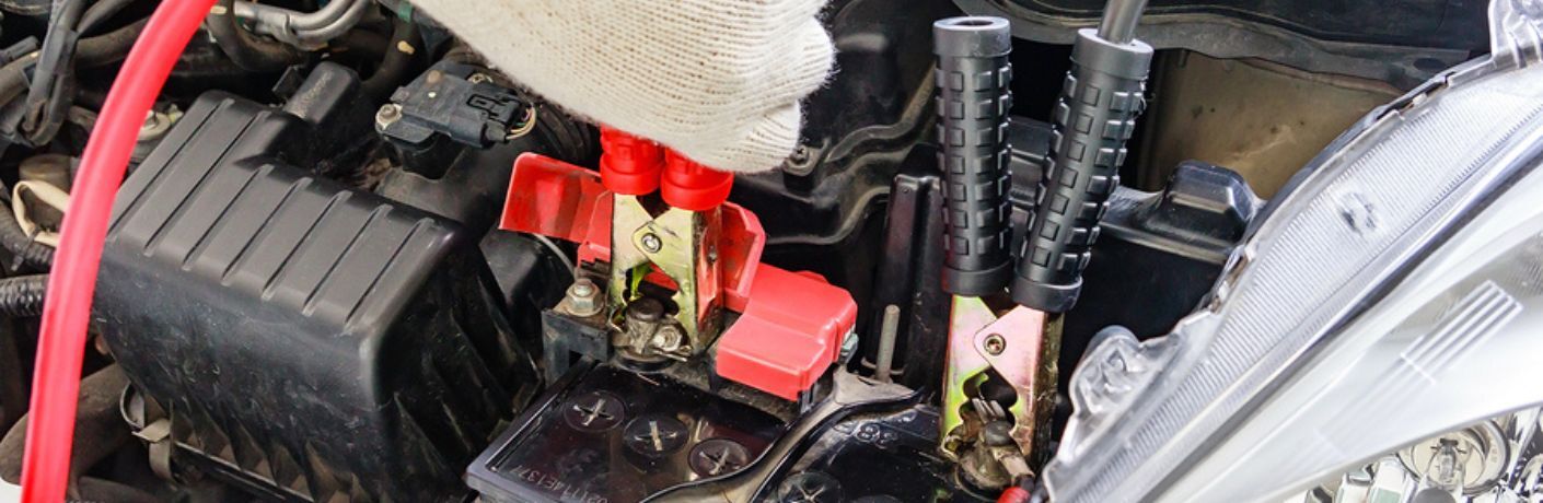 Jumper cables being used to jump-start the battery