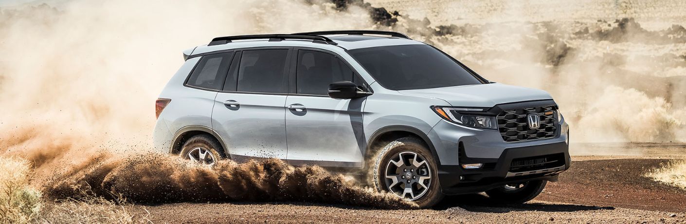 Side view of the 2024 Honda Passport navigating muddy terrain
