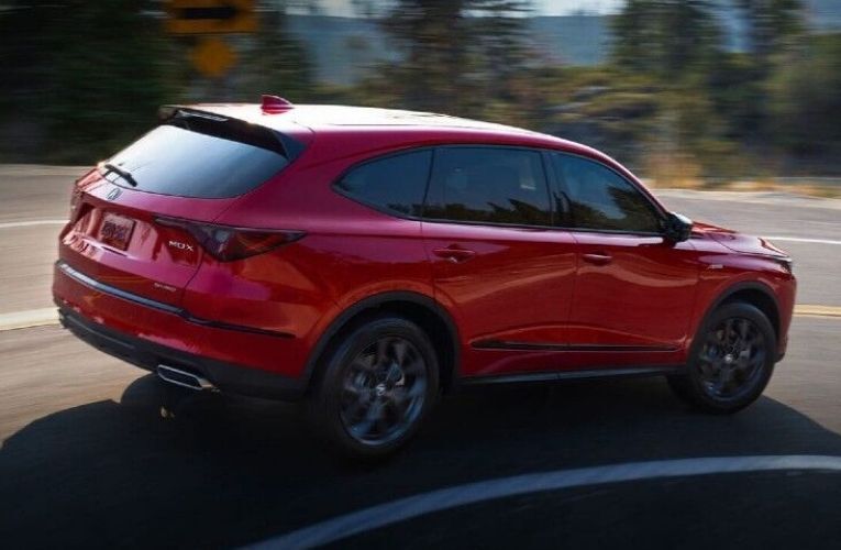 Used Acura MDX Red driving on the road Used Acura MDX Red driving on the road