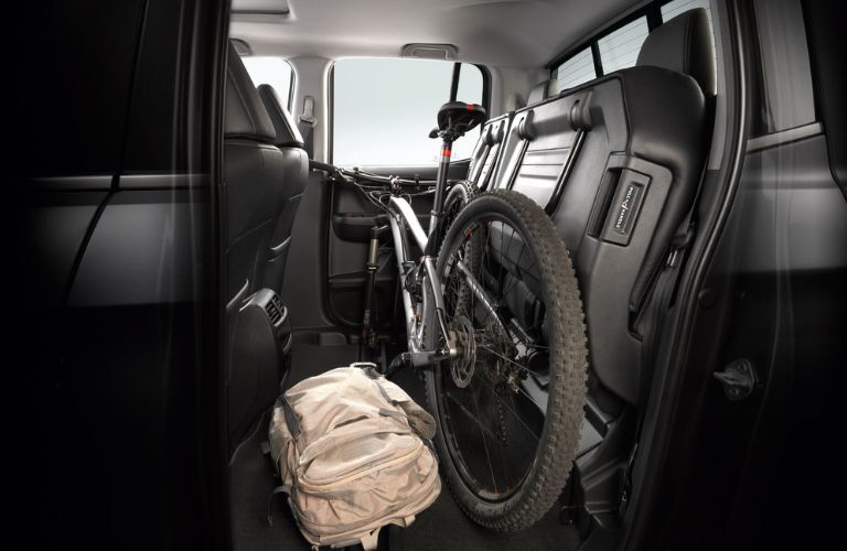 a cycle and backpack placed in the rear seat of the 2025 Honda Ridgeline