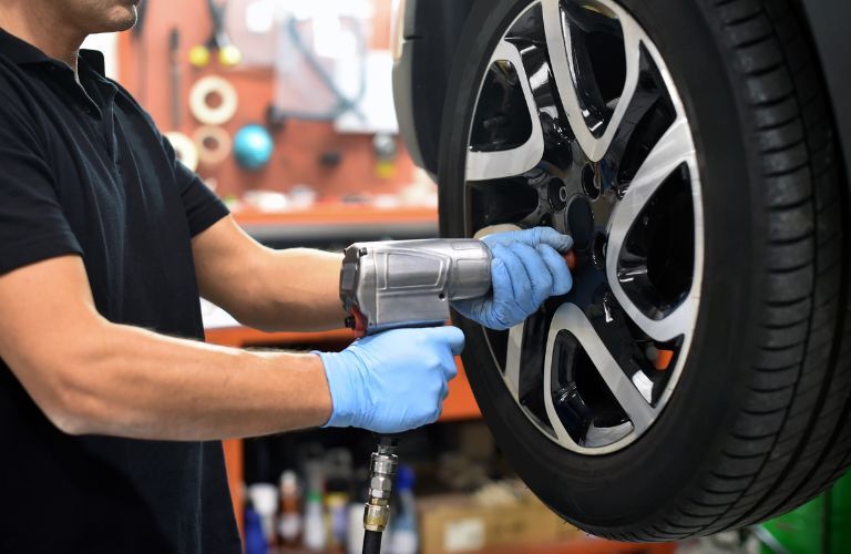 technician adjusting a tire as part of the tire rotation service
