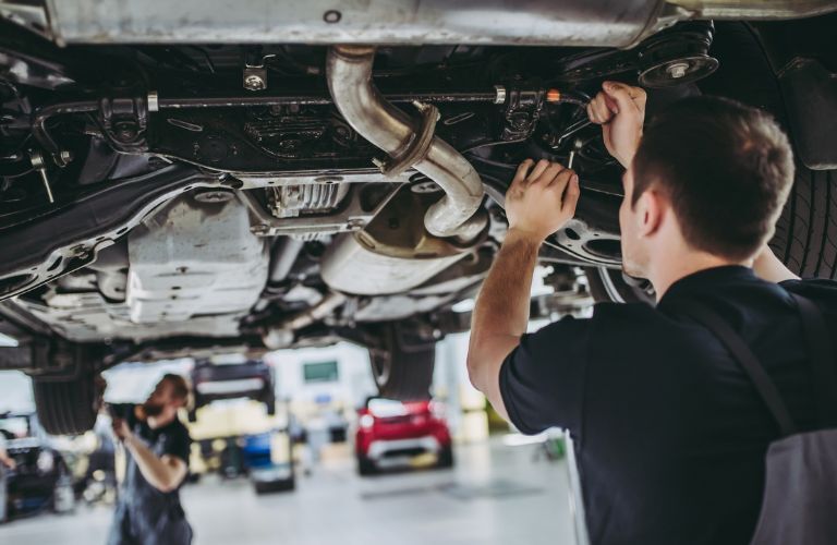 Technicians checking the underside of the vehicle