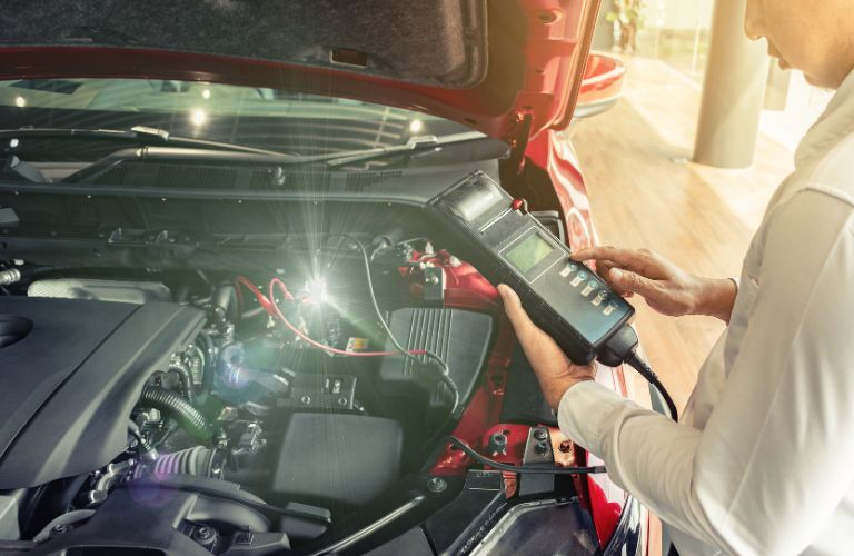 Technician inspecting a battery after terminal cleaning