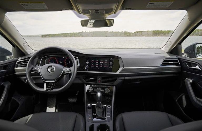 Front row interior of the 2020 Volkswagen Jetta with the steering wheel and touchscreen display in view