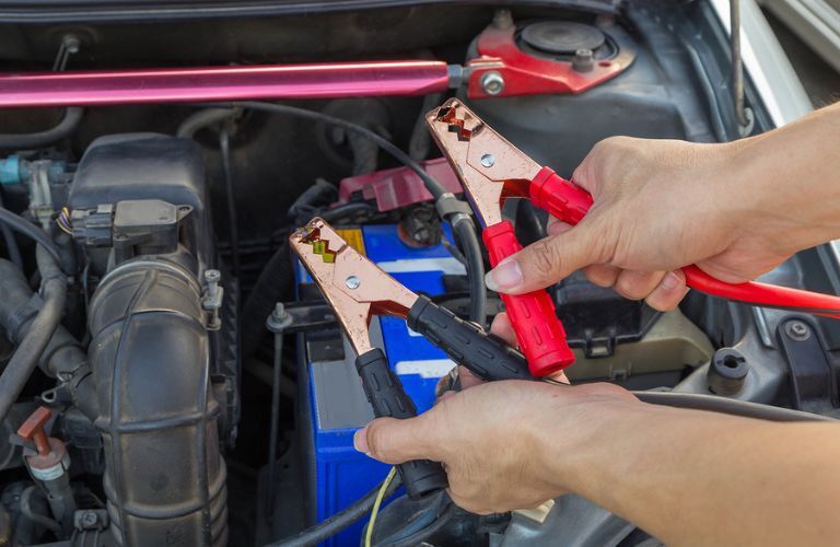 jumper cables being used to jump-start the battery