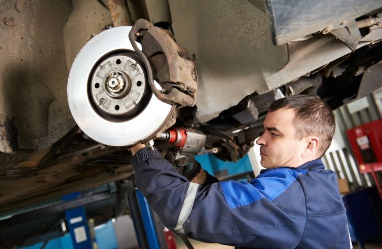 technician adjusting a brake rotor at a service station