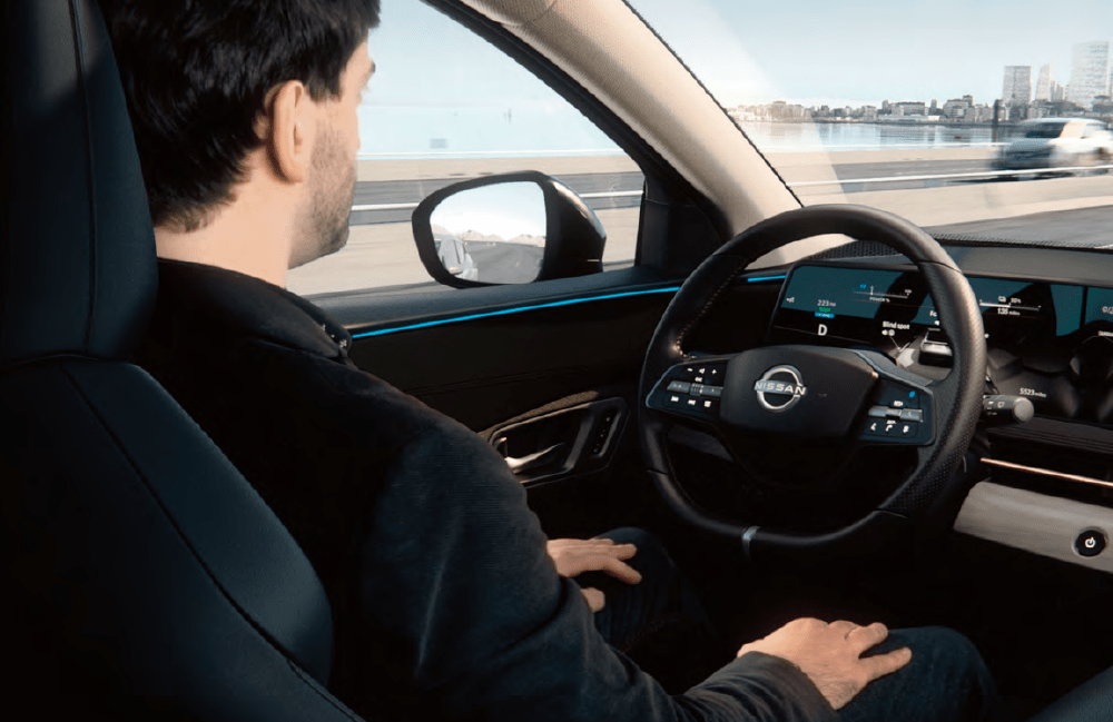 Man sitting in driver's seat of Nissan EV Man sitting in driver's seat of Nissan EV