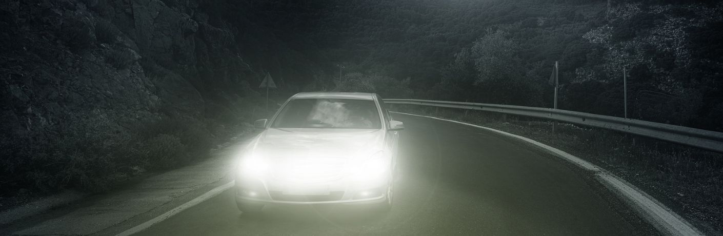 Car driving with headlights at night