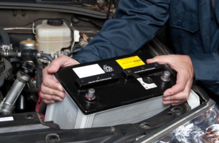 Mechanic replacing a car battery Mechanic replacing a car battery