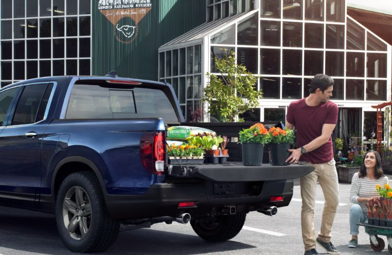 A couple placing plants in the cargo bed of the 2024 Honda Ridgeline