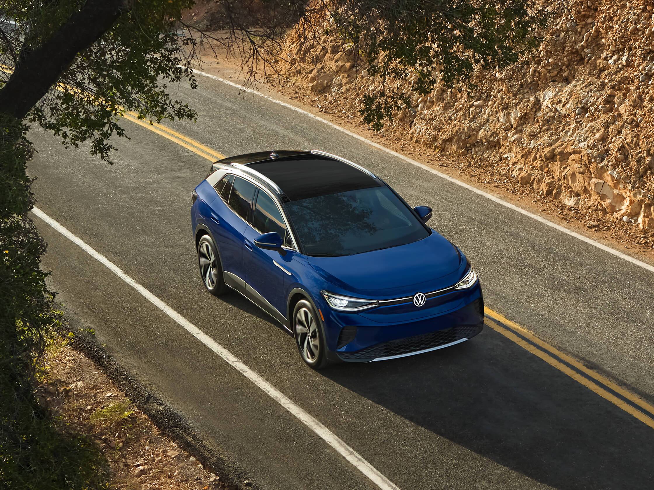 An ID.4 in Dusk Blue Metallic drives on a one-lane highway. An ID.4 in Dusk Blue Metallic drives on a one-lane highway.