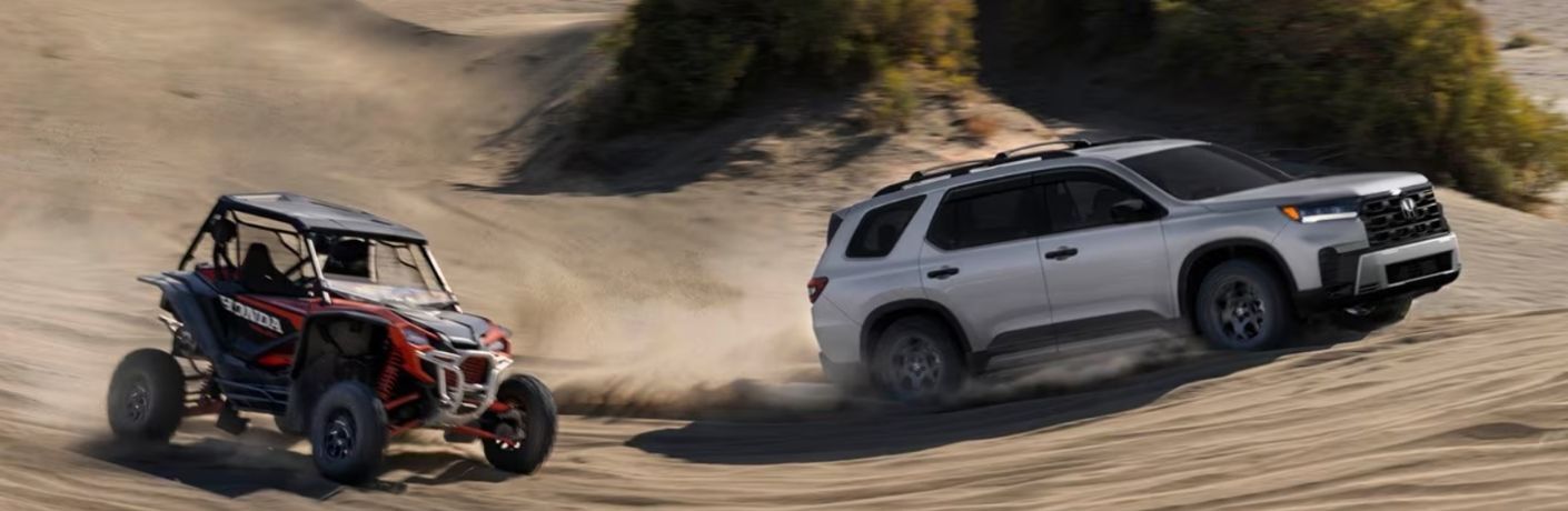 side view of a 2026 Honda Pilot racing an ATV in a desert
