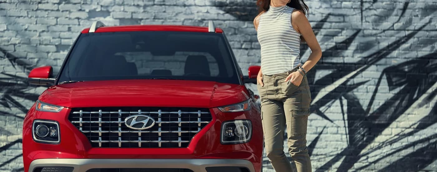 Red 2022 Hyundai Venue parked in front of a wall.
