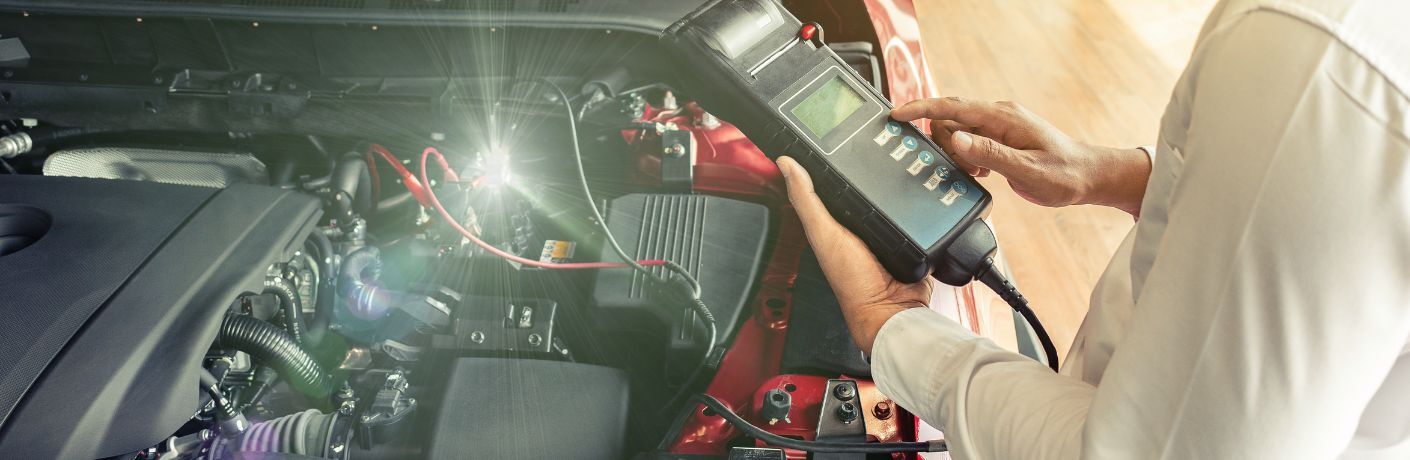 Technician checking the battery of a car after installation