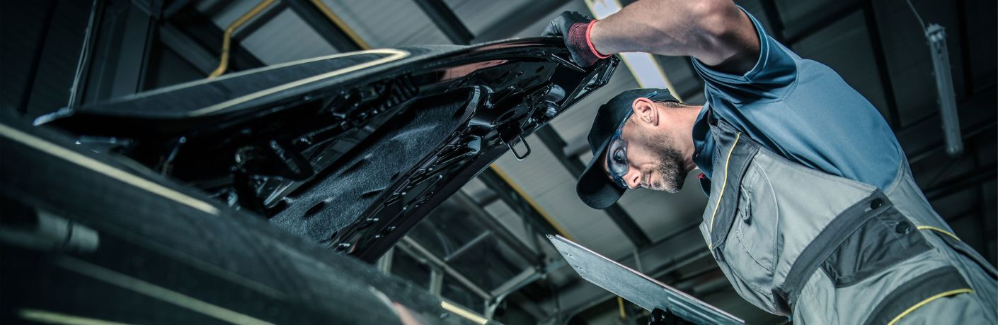 Technician checking under the hood of the vehicle