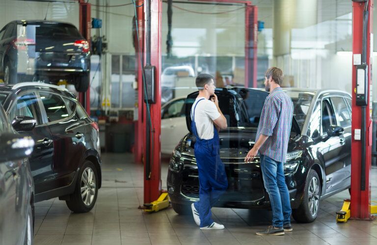 two men contemplating the service needed for a car