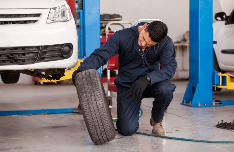 Service professional looking at a vehicle's tire