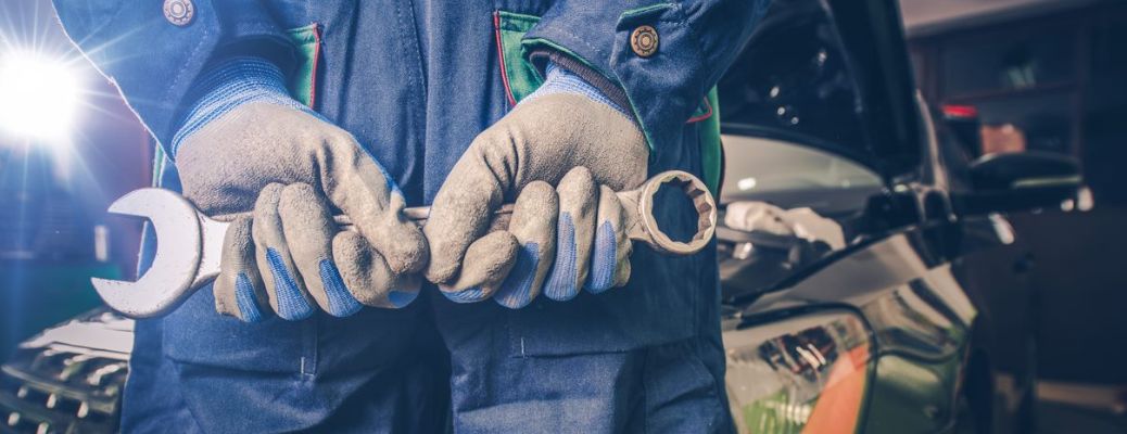 Technician standing with a tool in his hand with his back to the camera