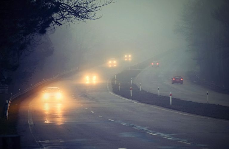 Cars driving in the fog with fog lights on