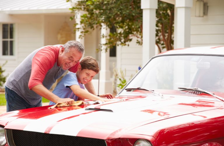 grandfather and grandson washing a car