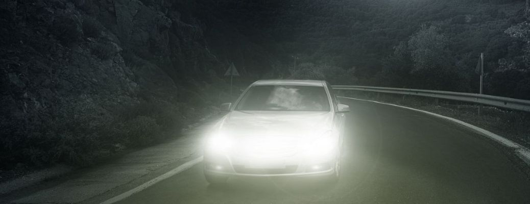 representative image of a car driving using headlights at night
