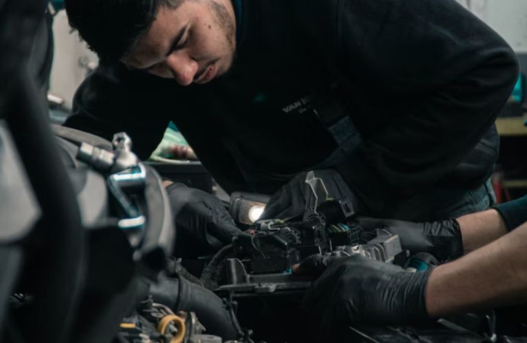 technician checking under the hood of the vehicle