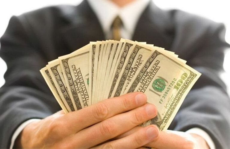 Person holding spread out cash