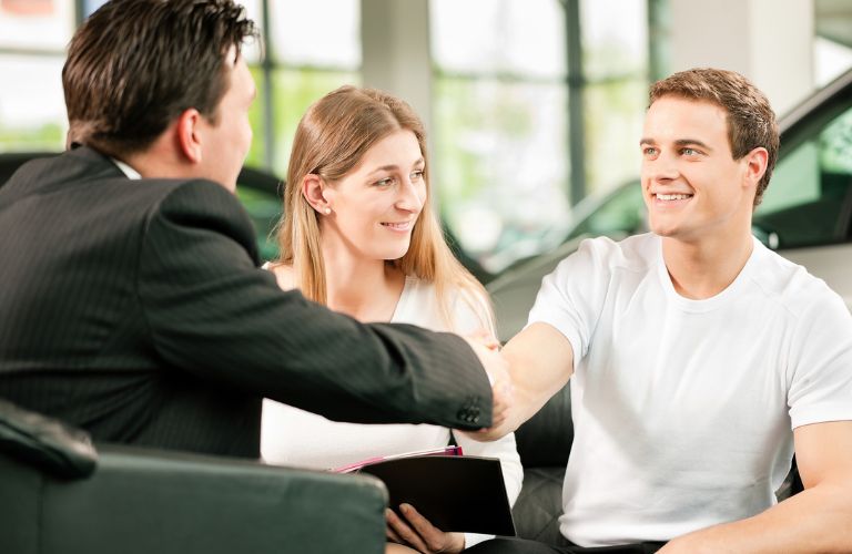 two men shaking hands at a dealership