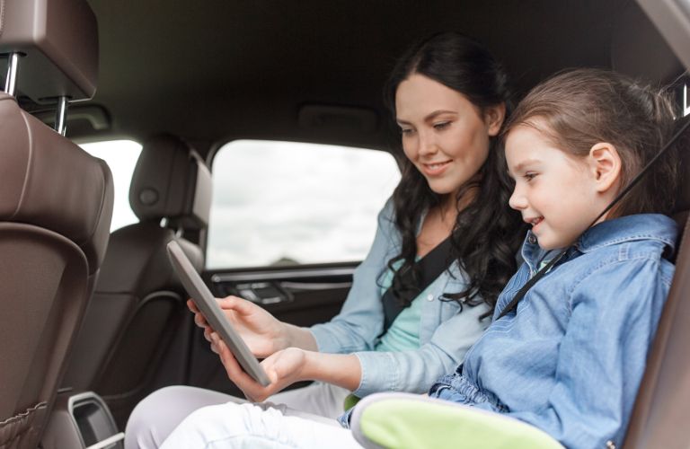 a woman and young girl sitting in a car