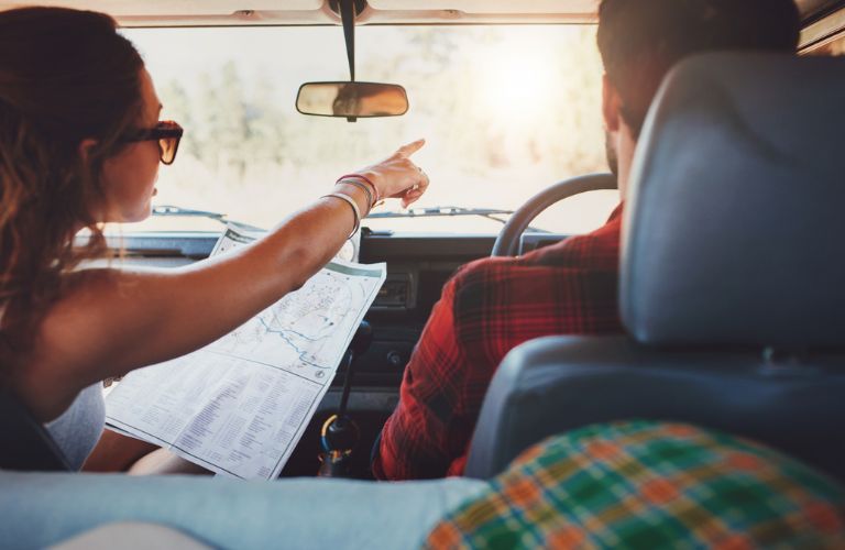 couple reading a map in a car