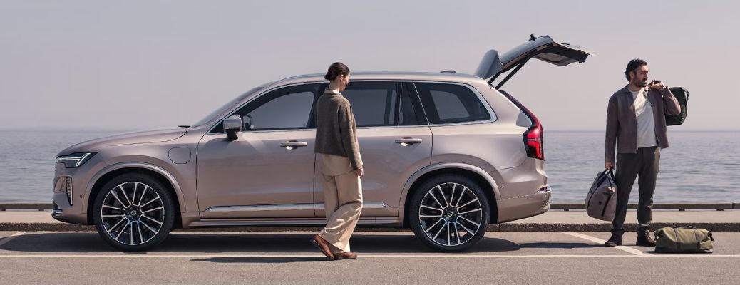Two people beside a Volvo XC90