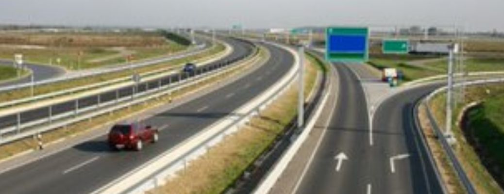 view of a highway with a red car