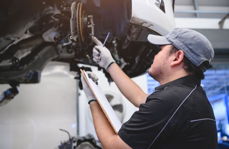 Service professional inspecting a vehicle's brake