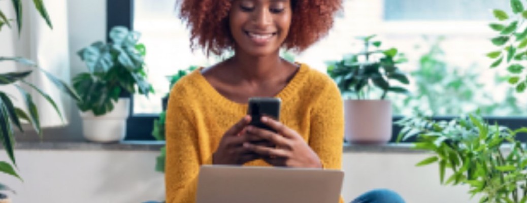 a person looking at their phone in front of their laptop